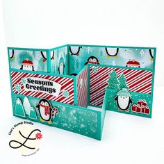 two christmas card holders with penguins and snowmen on them, one is open to show the