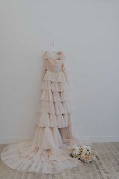 a dress hanging on a wall next to flowers