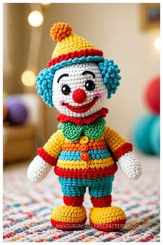 a crocheted clown doll sitting on top of a bed with lights in the background