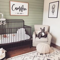 a dog sitting in a crib next to a baby's room with a sign on the wall