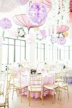 tables and chairs are set up with umbrellas hanging from the ceiling in front of them