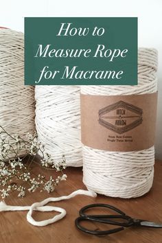 two rolls of rope sitting on top of a wooden table next to scissors and twine