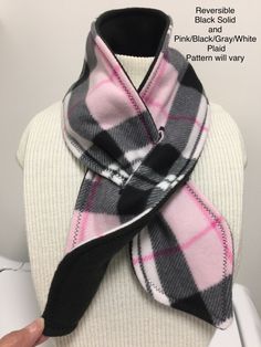 a pink and black plaid scarf on top of a white mannequin headdress