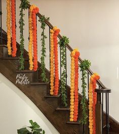 some orange and yellow balloons are hanging on the banisters in front of a staircase