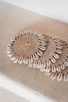 two woven baskets are sitting on the floor next to each other with shells embedded in them