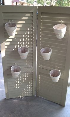 three white buckets are hanging on the side of a door