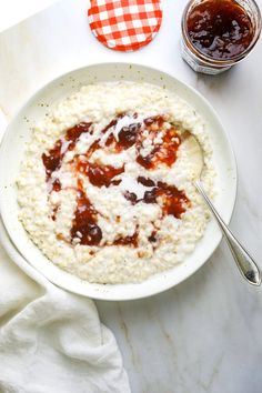 a bowl of oatmeal with strawberry jam on top