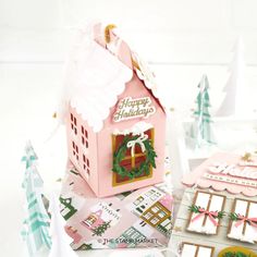 there is a small pink house on top of some cards and other things in front of it