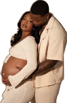 a man and woman embracing each other in front of a white background with the pregnant belly visible