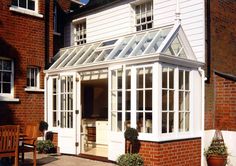 a white house with an orangery roof in front of it and the words beautiful custom orangeries from 2009 call us today