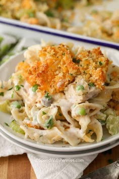 a close up of a plate of food with pasta and vegetables in it on a table