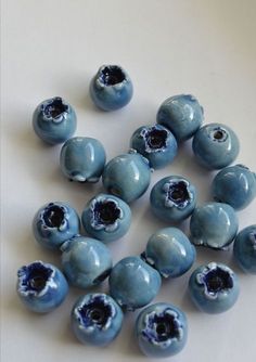 blue beads with holes in them on a white surface