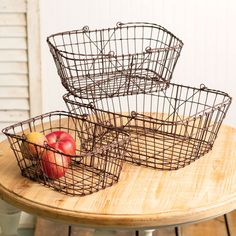 three wire baskets sitting on top of a wooden table