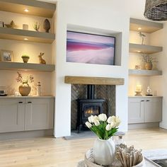 a living room filled with furniture and a fire place in front of a flat screen tv