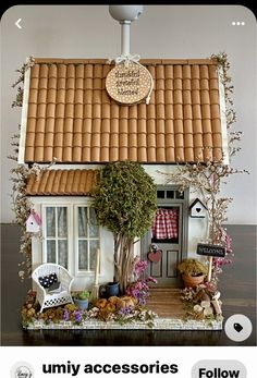 an image of a doll house made out of wood and fake plants on the roof