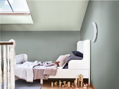 a bedroom with a white bed and wooden toys on the floor next to a stair case