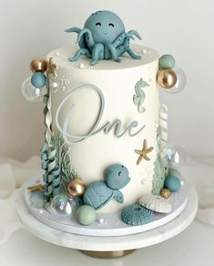 a one tiered cake decorated with an octopus and other sea creatures is on a plate