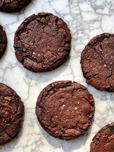 chocolate cookies are arranged on a marble surface