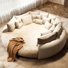 a large round couch with pillows on top of it