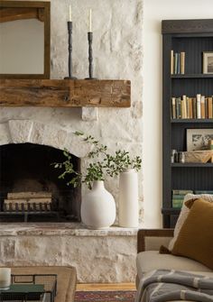 a living room filled with furniture and a fire place in front of a book shelf