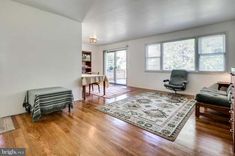 a living room with hard wood floors and white walls