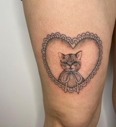 a cat with a bow in the shape of a heart is shown on this woman's thigh