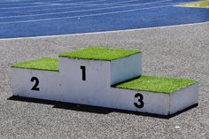 the grass is growing on top of the pedestals in front of an empty parking lot