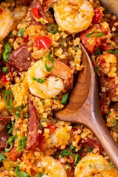 shrimp and rice dish with wooden spoon in pan