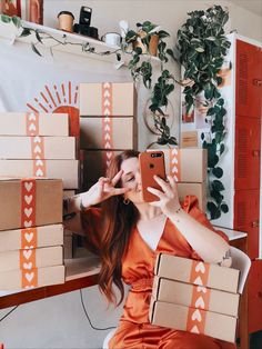 a woman in an orange dress is holding up her phone