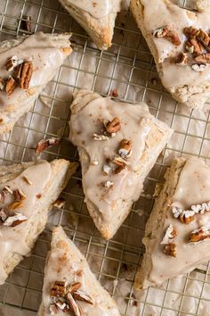 several pieces of cake with frosting and pecans sitting on a wire cooling rack