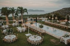 an outdoor venue with tables and chairs set up for a formal function by the water