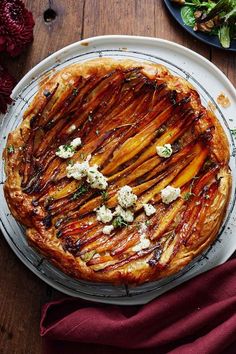 a pie is sitting on a plate next to a salad