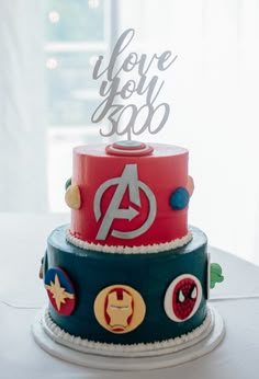 the cake is decorated with captain america symbols and iron - man letters that spell out i love you dad