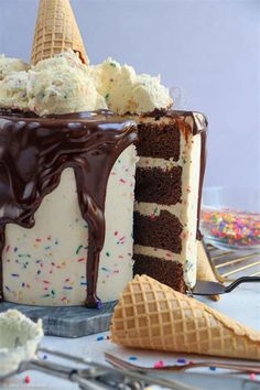 a chocolate cake with ice cream and sprinkles next to an ice cream cone