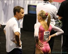 a man standing next to a woman in a pink leotard