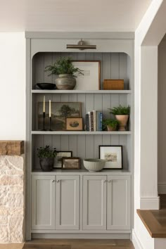 a book shelf with books and plants on it