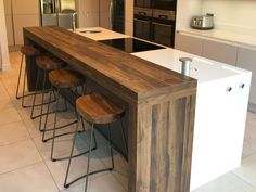 a kitchen island with four stools next to it