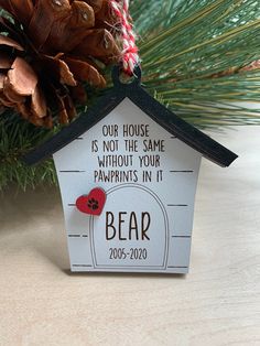 a house shaped ornament with a bear on it