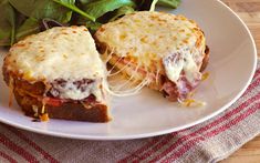 a white plate topped with a sandwich and salad on top of a red and white checkered table cloth