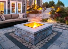 a fire pit sitting in the middle of a patio next to a couch and table