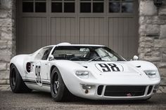 a white race car parked in front of a garage