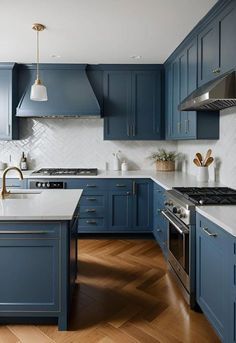 a large kitchen with blue cabinets and white counter tops, hardwood flooring, and stainless steel appliances