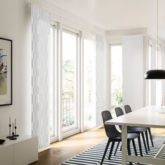 a dining room with white walls and black chairs