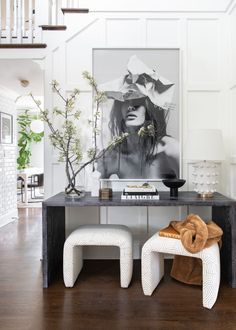 a table with two stools and a painting on the wall