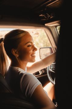 a woman sitting in the driver's seat of a car