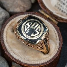 This antique 1927 class ring features a black enamel center with the letters SPS in gold. The ring has a pierced open work floral motif decorating the shoulders and gallery. It is crafted of 10k yellow gold and is currently a size 7.75. There is a small amount of enamel loss in the top right corner of the center but this is difficult to see. Antique Mens Rings, Antique Cocktail Ring, Class Rings, Men's Rings, Men's Jewelry, Black Enamel, Cocktail Rings, Floral Motif, Vintage Rings