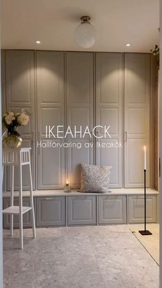 a white chair sitting on top of a floor next to a shelf filled with flowers