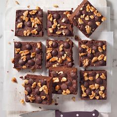 chocolate brownies with walnuts on top and a knife