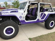 a purple and white jeep is parked on the sidewalk