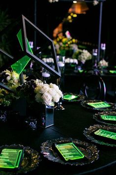 a table topped with plates and vases filled with white flowers on top of it